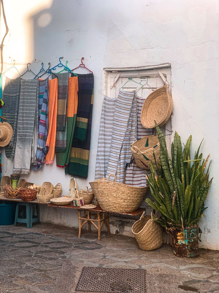 Services Colorful scarfs and handmade baskets displayed in Asilah, Morocco.