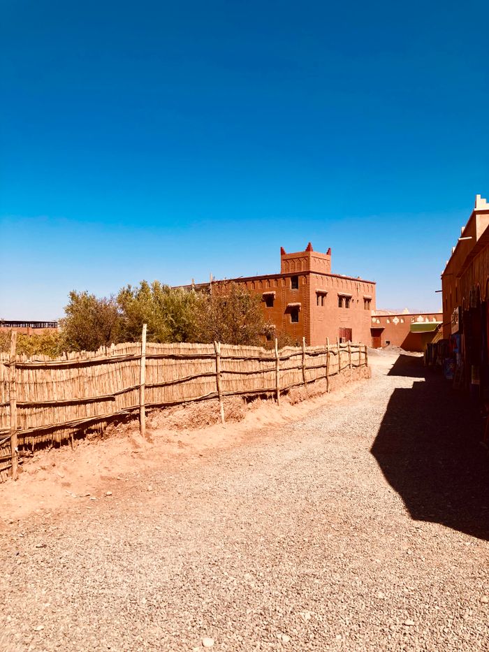 Services A rustic building in Morocco, showcasing traditional Berber architecture under a clear blue sky.